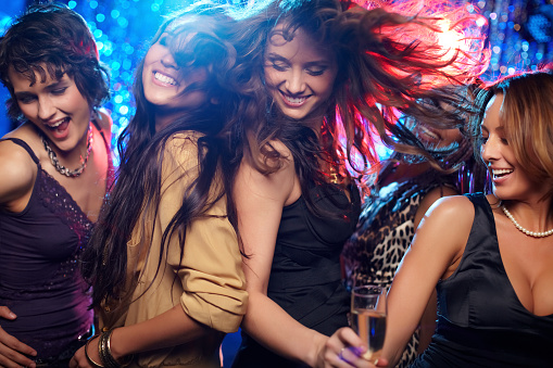 Group of young people attending party, dancing, having fun over dark background in neon light. Hippie generation. Concept of youth culture, leisure time activity, fun, lifestyle