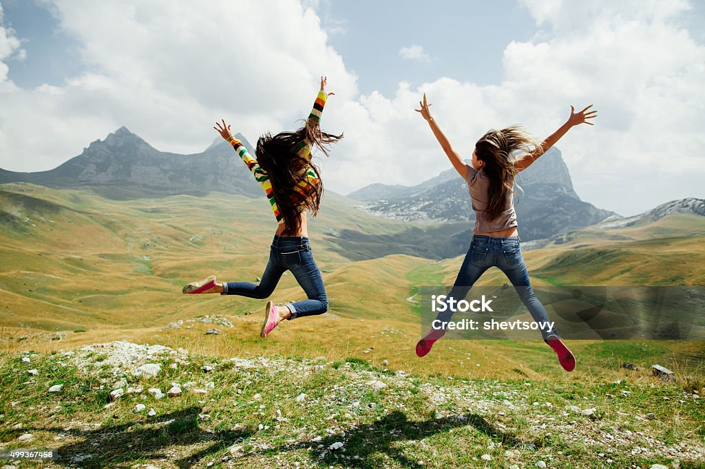 Zwei Mädchen glücklich Sprung in den Bergen - Lizenzfrei Hochspringen Stock-Foto
