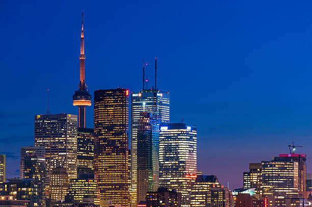 grattacieli scintillanti futuristico paesaggio urbano al tramonto illuminato toronto, ontario canada - toronto skyline cn tower night foto e immagini stock