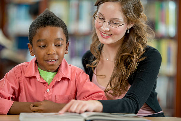 istock Librarian Reading a Book with a Little Boy 499369144