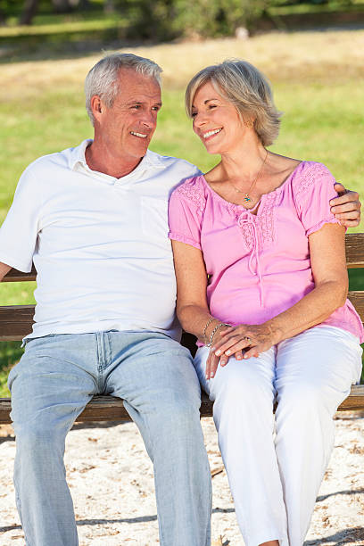 istock Happy Senior Couple Sitting on Bench in Sunshine 499369636
