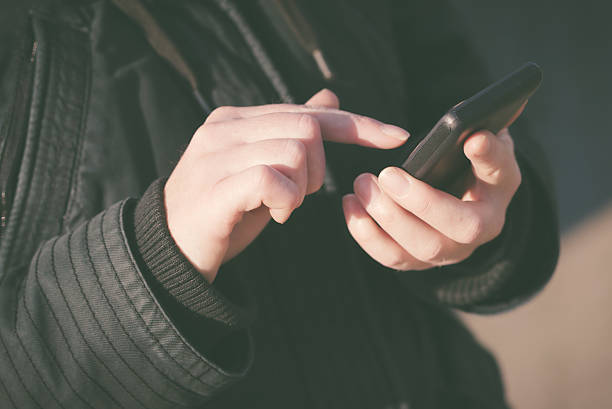 femme écrire un texto message sms sur téléphone mobile - retro revival telephone human hand toned image photos et images de collection