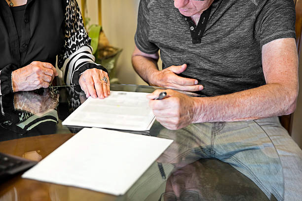 caucásica senior hombre firma del acuerdo de hipotecas para el nuevo hogar - success signing businesswoman serious fotografías e imágenes de stock
