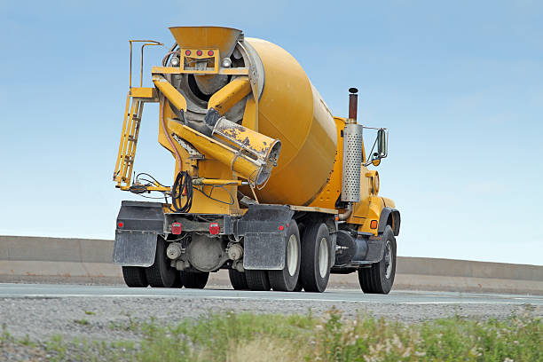 istock Yellow Cement Truck On Highway Delivering Concrete To Construction Site 499371254