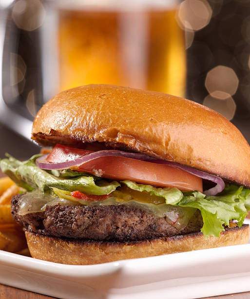 istock cheeseburger with mug of beer in background 499377897