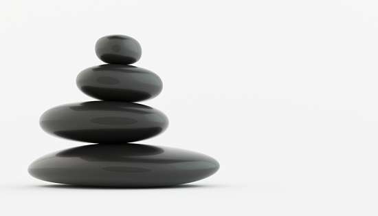 Stack of black zen stones on white floor, spa concept.