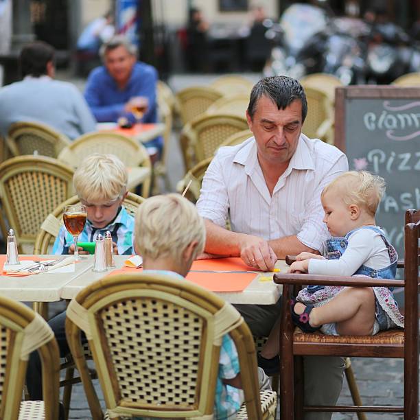 istock Family eating and drinking in outdoors italian cafe 499382087
