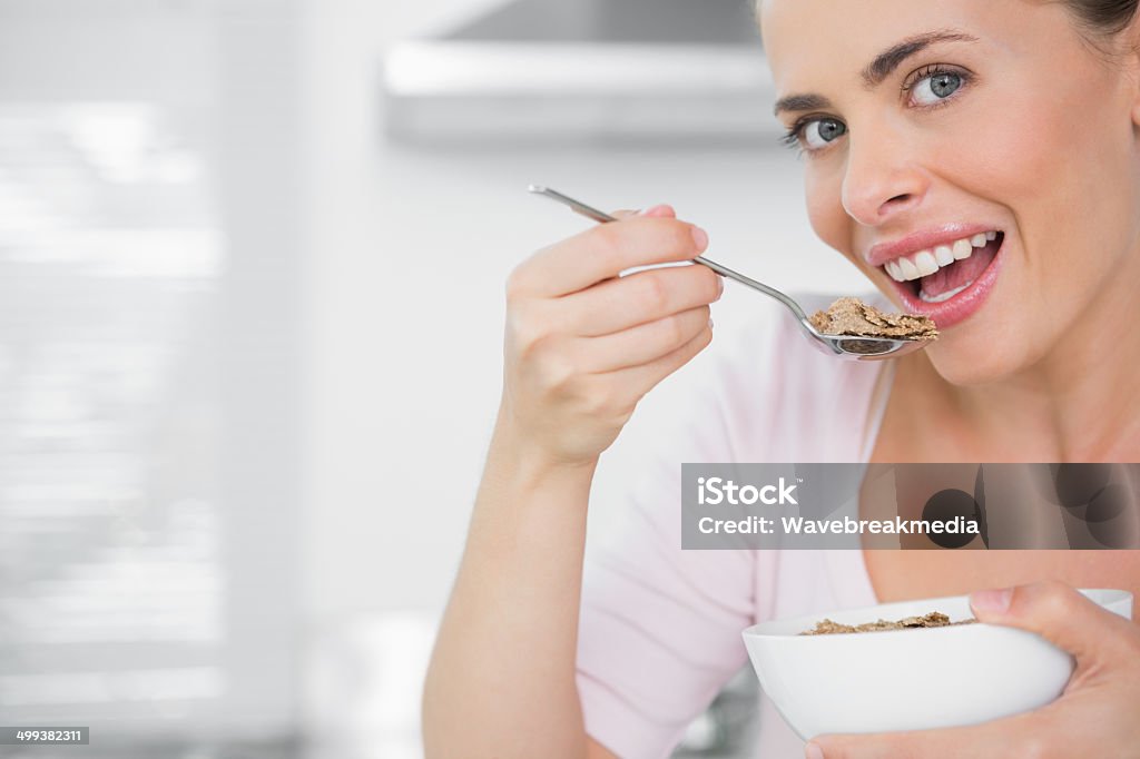 Pretty woman holding bowl of cereal Pretty woman holding bowl of cereal in her kitchen 30-39 Years Stock Photo