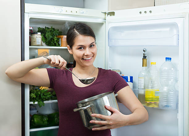istock Hungry brunette standing near fridge 499389360
