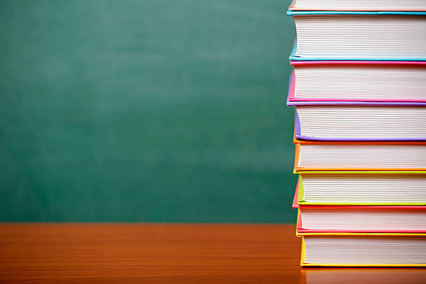istock Stack of books on a green chalkboard background 499391710