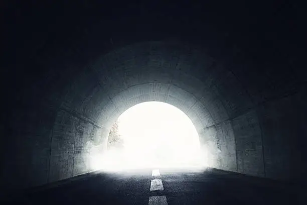 Darken tunnel with fog and light at the end of tunnel