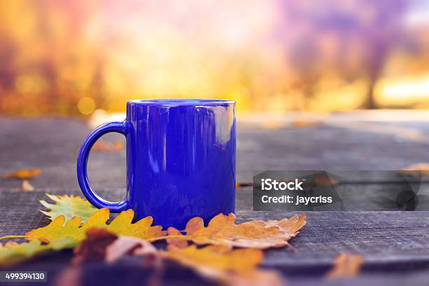 Blue Cup On Wooden Table With Autumn Blurred Background Stock Photo - Download Image Now