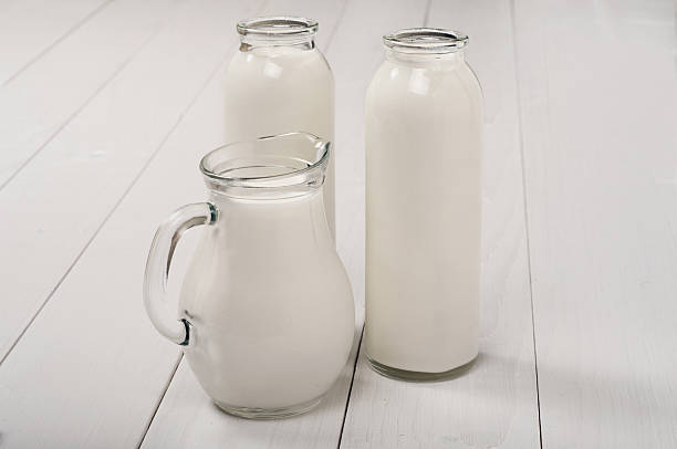 istock Milk bottles and decanter on a wooden table 499395462