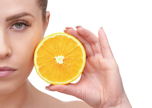 perfect portrait of woman holding orange and looking at camera, green eyes, healthy eating and healthy lifestyle concept.