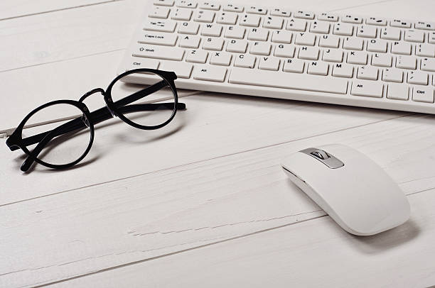 istock White slim keyboard with a white slim mouse and glasses 499397590