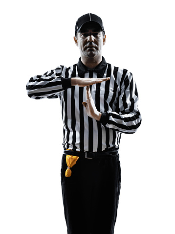 Low angle view of football judge holding a yellow flag against the sky.