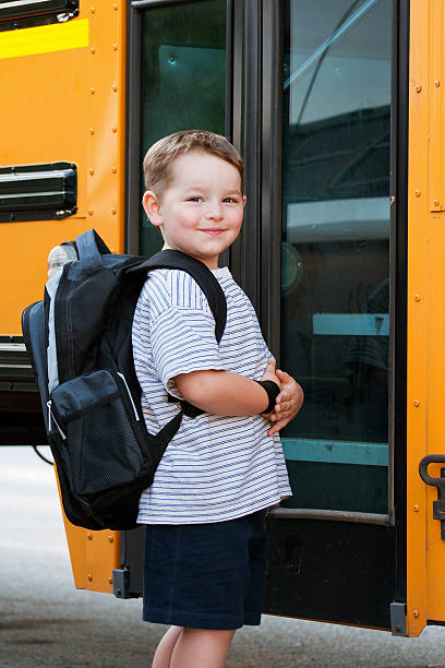 istock Happy young boy in front of school bus 499400809