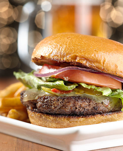 istock cheeseburger with mug of beer in background 499406631