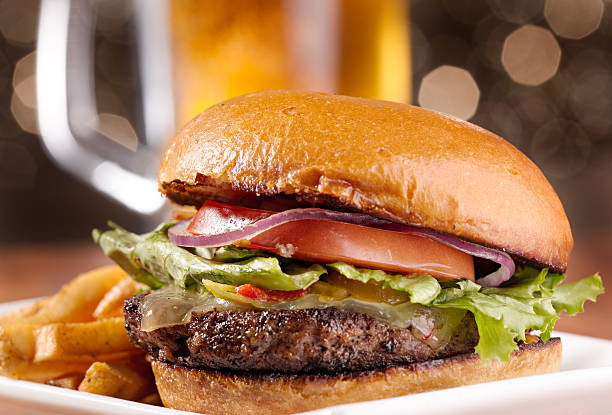 cheeseburger with mug of beer in background