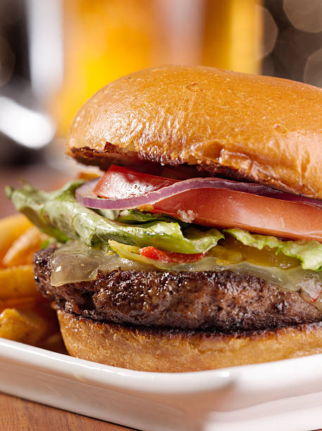 istock cheeseburger with mug of beer in background 499406637