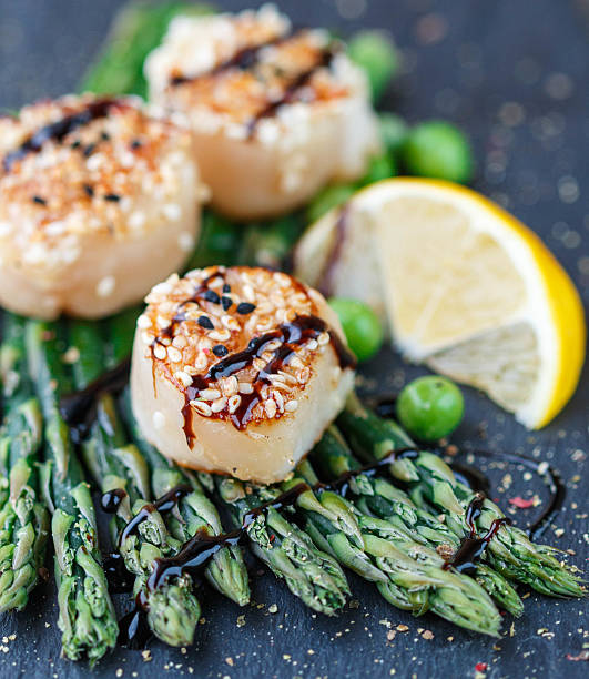istock Fried scallop  with sesame seeds, balsamic sauce and asparagus 499417928