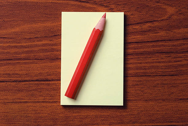 istock Paper and  red pencil on wood background 499419319