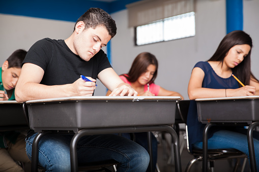 Several high school students taking a test in a classroom
