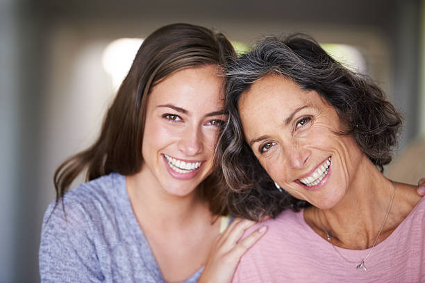 She's my mom, sister and best friend, all in one! A laughing mother and daughter standing in their home and looking at the camerahttp://195.154.178.81/DATA/i_collage/pu/shoots/784547.jpg gray hair young woman stock pictures, royalty-free photos & images