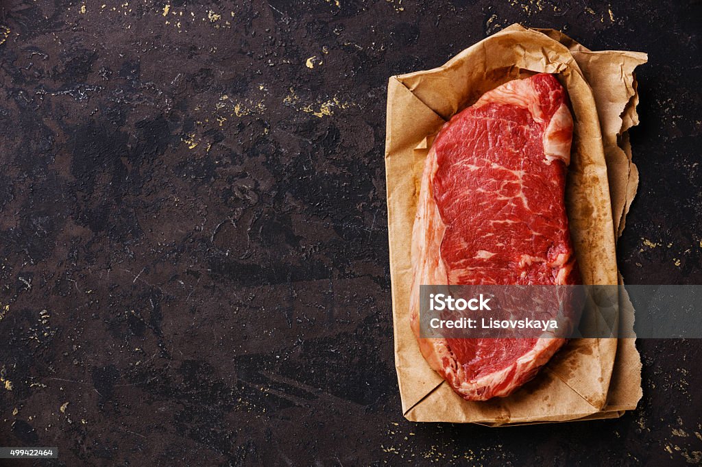 Raw fresh meat steak on kraft paper Raw fresh meat Striploin steak on kraft paper background Brown Paper Stock Photo