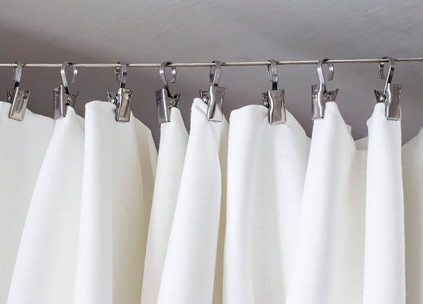istock cream-colored curtain hanging on a string on metal hooks illumin 499423636