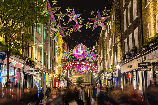 London, UK - November 27, 2015: Lights down Carnaby Street in London during the Christmas Season. Large amounts of people can be seen.