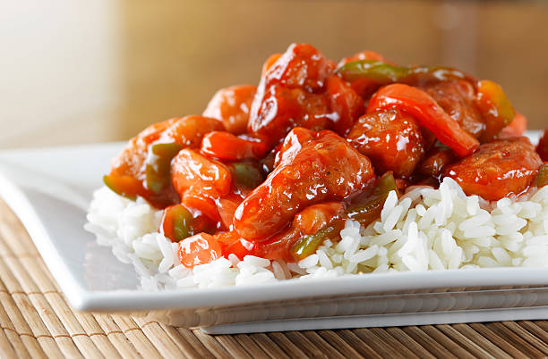 sweet and sour chicken on rice stock photo