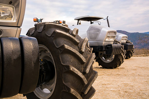 istock Front tires of three gray tractors parked side by side. 499424990