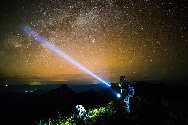 istock Young man Standing on Mountain with night sky 499433427