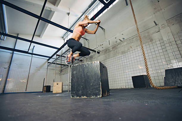 istock Fit woman is performing box jumps at gym 499435147
