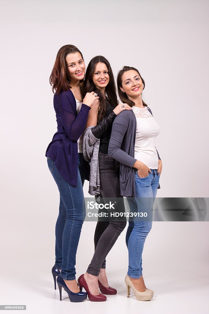 Portrait of three girls, in high heel shoes. Portrait of three girls, in high heel shoes. Studio shot, white clean background Short Person Stock Photo