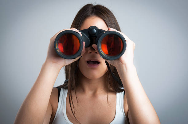 istock Binoculars woman looking surprised at camera - close up 499450174