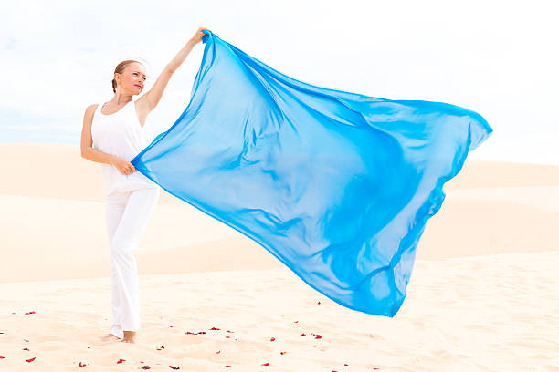 istock Young woman with flying blue scarf 499451419