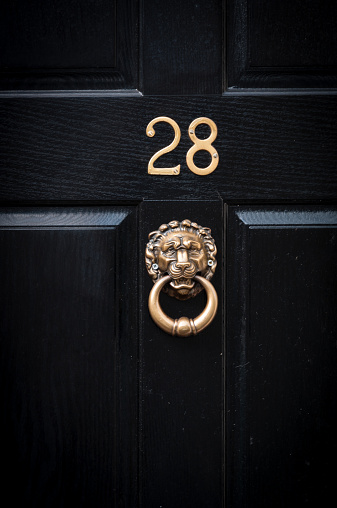 Close up of door number twenty eight and door knocker for background use and greeting cards