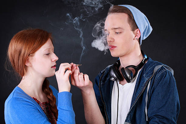 Teenagers smoking marijuana joint Horizontal view of a teenagers smoking marijuana joint child crimes stock pictures, royalty-free photos & images