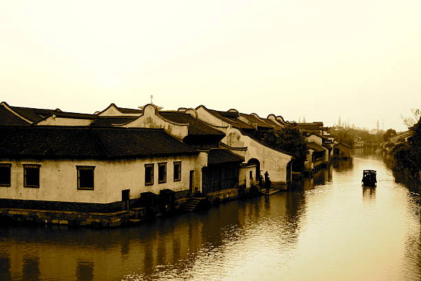Traditional houses near the river in China. A boat is floating.