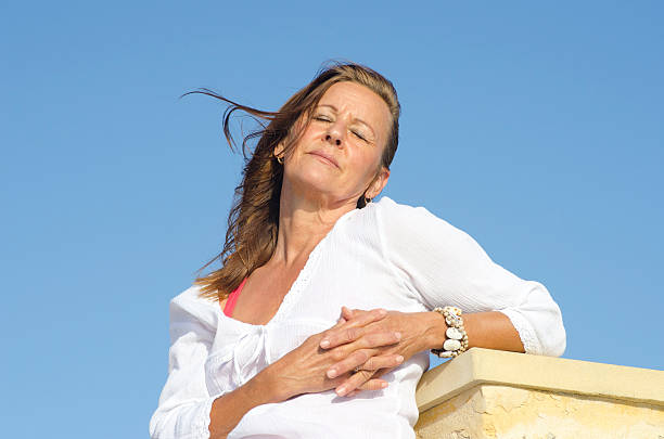 A radiant young woman stands on a sunlit terrace, her face gently illuminated by the golden hues of dawn
