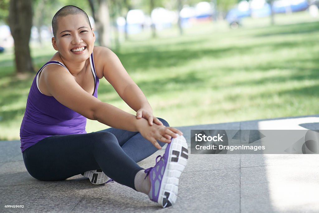 Exercising woman Vietnamese bald woman doing exercising outdoors Cancer - Illness Stock Photo