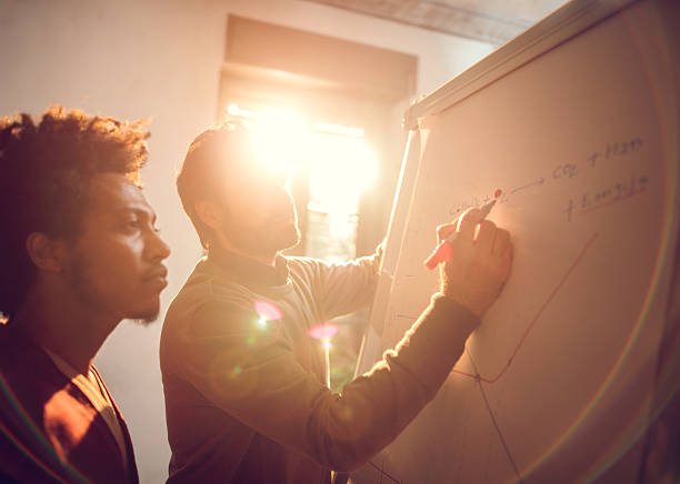 istock Businessmen cooperating while drawing a business chart at office. 499459558