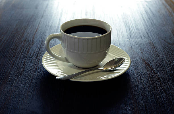 caneca branca repleta de café no pires e colher de chá - black coffee coffee single object drink - fotografias e filmes do acervo