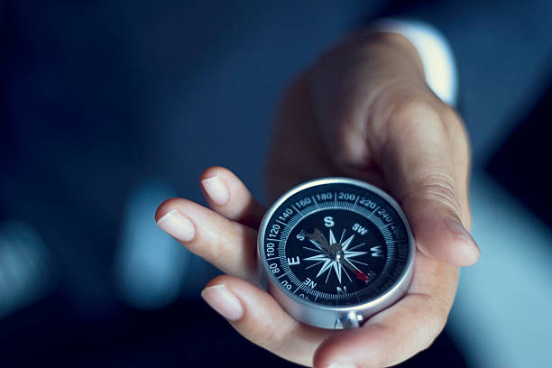 Businessman with a compass holding in hand Businessman with a compass holding in hand, color tone film look guide stock pictures, royalty-free photos & images