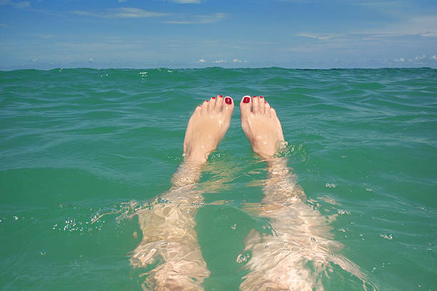 istock Woman's Legs Floating In Ocean 499465161