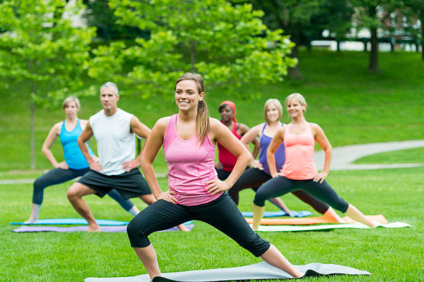 jogi na świeżym powietrzu - yoga class caucasian young adult group of people zdjęcia i obrazy z banku zdjęć