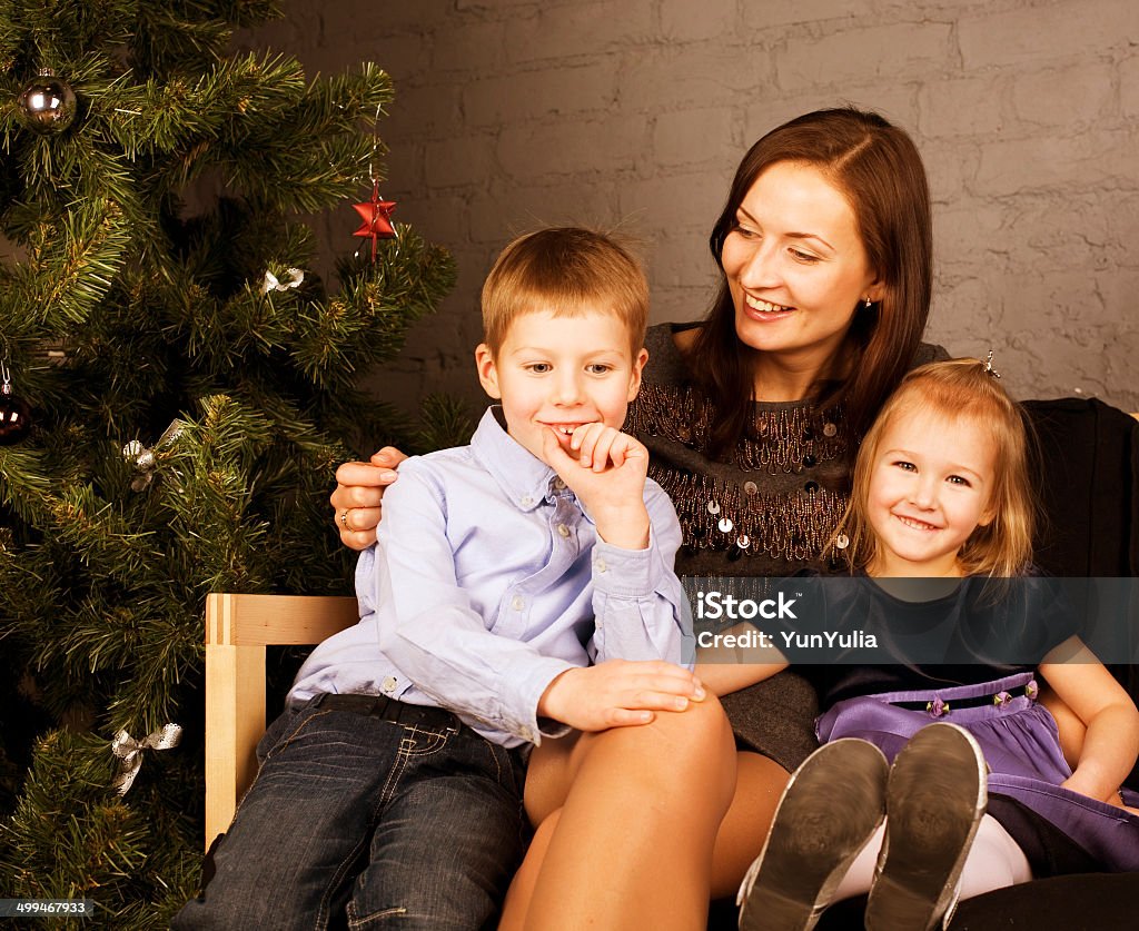 happy family at christmas tree happy family at christmas tree sitting home smiling Adult Stock Photo