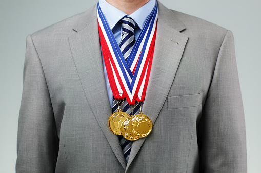 Gold medals hanging around a businessman neck concept for success and winning in business